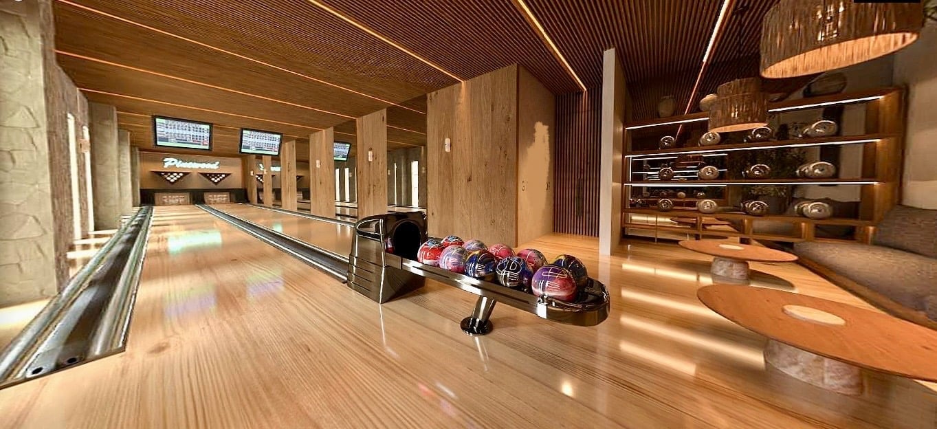 Modern indoor bowling alley with polished wood lanes, bowling balls displayed, and warm wood and lighting design throughout.