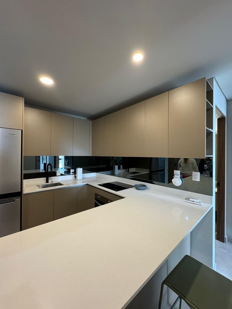 Modern kitchen with white countertops, beige and black cabinetry, black backsplash, and recessed lighting in ceiling