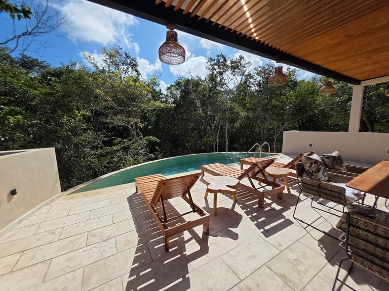 Modern patio with wooden chairs and pool overlooking forest, under covered pergola structure