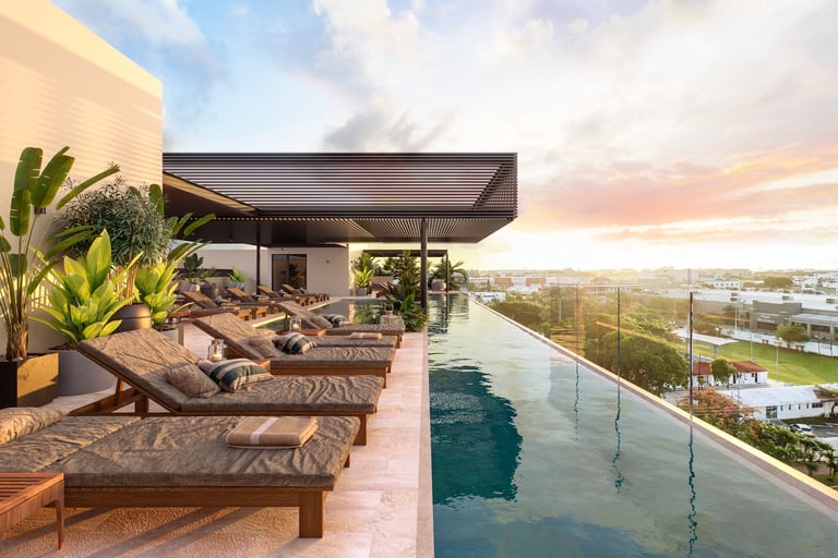 Luxury rooftop patio with lounge chairs, plants, and infinity pool overlooking coastal landscape at sunset