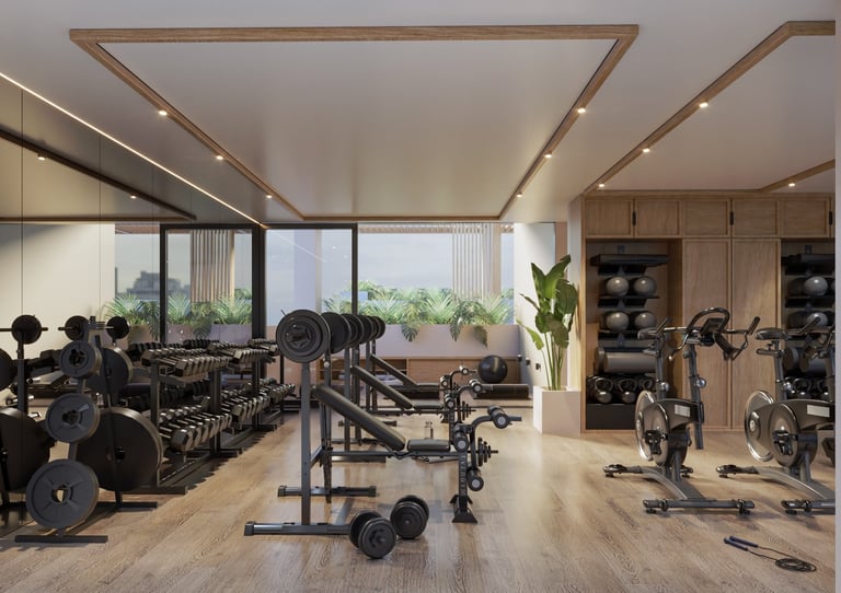 Modern home gym interior with exercise equipment, weight racks, stationary bikes, and large windows overlooking outdoor views