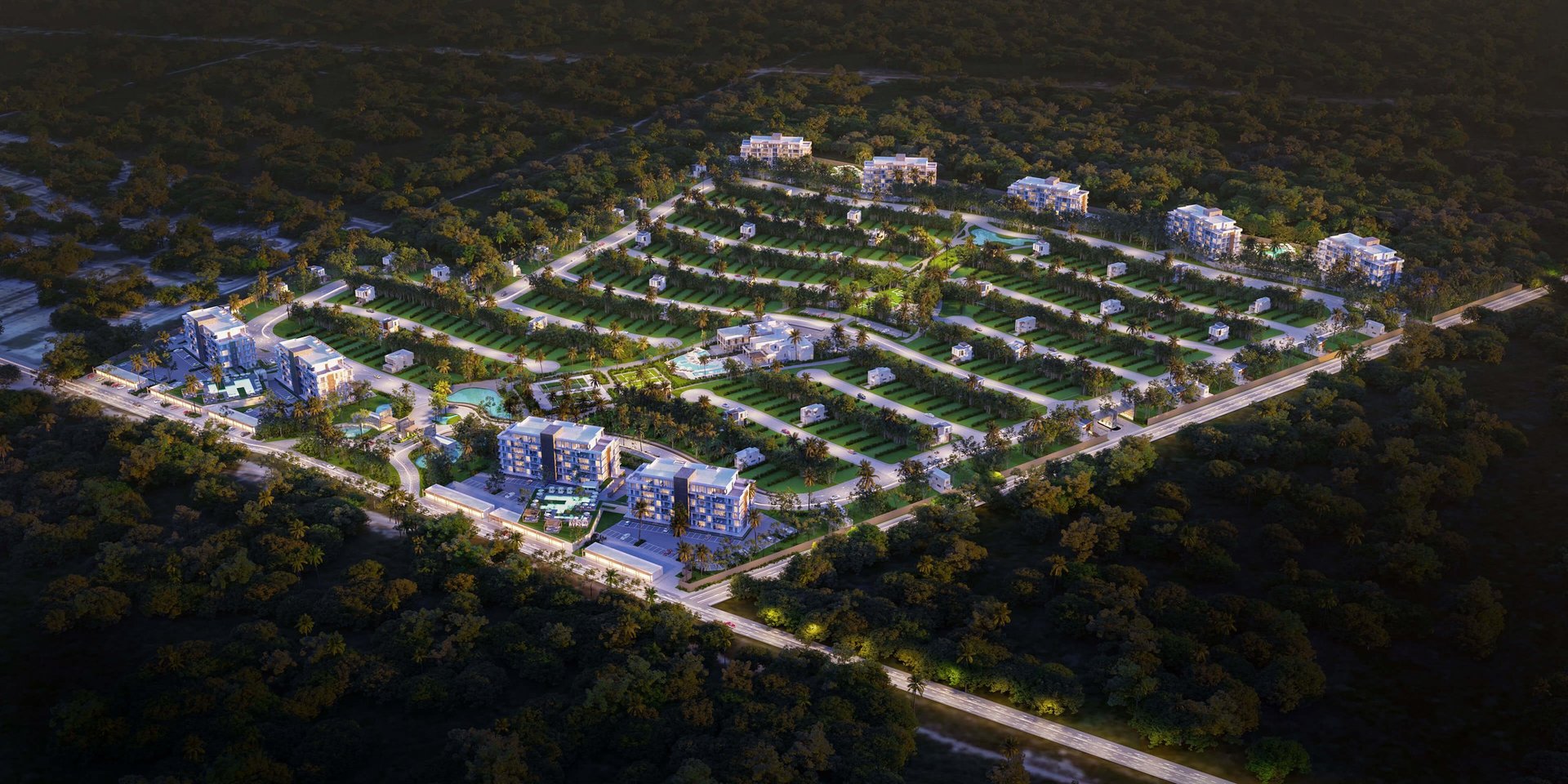 Aerial night view of a residential development with organized street grid, modern buildings, and landscaping surrounded by forest